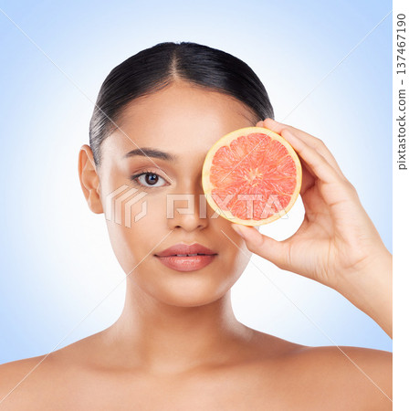 Beauty skincare, portrait and woman with grapefruit for organic collagen treatment, natural self care or fruit benefits. Vitamin C, citrus product or studio face of wellness person on blue background 137467190
