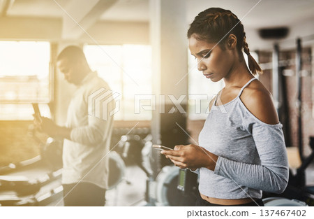 Fitness, gym and woman with a phone for communication, internet and workout app. Serious athlete person with a smartphone for texting, influencer post or online for wellness and health space or flare 137467402