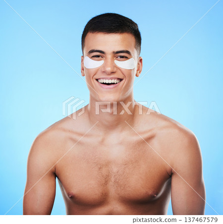 Happy man, beauty and smile with eye patch for skincare, grooming and clean with hygiene on blue background. Skin treatment, cosmetics product and wellness, portrait and dermatology in a studio Happy man, beauty and smile with eye patch for skincare, grooming and clean with hygiene on blue background. Skin treatment, cosmetics product and wellness, portrait and dermatology in a studio 137467579
