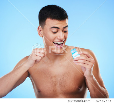 Dental floss, happy man and teeth cleaning for healthcare, wellness and morning care in studio. Blue background, male model and happy from hygiene with smile from healthy product for tooth protection 137467583