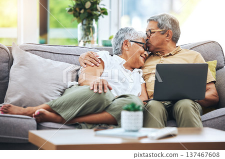 Laptop, love and senior couple on sofa for watching movies, entertainment or streaming in living room. Retirement, marriage and happy man and woman kiss on computer for bonding, relax or film at home 137467608