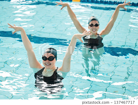Synchronized, women and competition in swimming pool performance, event or dance together in water or sport. Athlete, swimmer and people training for concert, dancing or duet with stretching arms Synchronized, women and competition in swimming pool performance, event or dance together in water or sport. Athlete, swimmer and people training for concert, dancing or duet with stretching arms 137467717