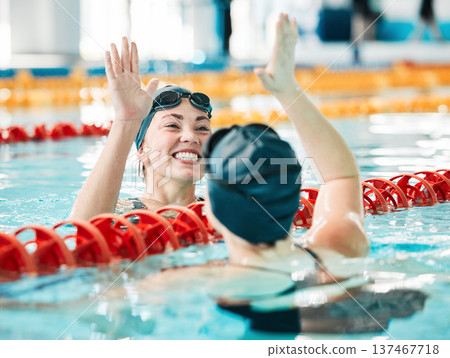 Fitness, swimmer and women with high five, celebration and achievement with workout, wellness and winning. Exercise, winner or champion in a pool, celebration or support with success, sports or smile 137467718