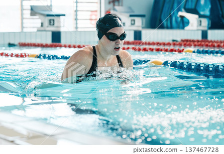 Swimming, athlete and sports woman in water for training, action and performance in competition, race and challenge. Pool, swimmer and underwater goggles for fitness, triathlon contest and exercise 137467728