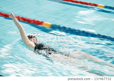 Sports, swimming pool and woman swimmer training for a race, competition or tournament. Fitness, workout and female athlete practicing back stroke cardio water skill for exercise, speed or endurance. Sports, swimming pool and woman swimmer training for a race, competition or tournament. Fitness, workout and female athlete practicing back stroke cardio water skill for exercise, speed or endurance. 137467732