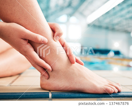 Sports injury, ankle pain and closeup with person at swimming pool for fitness, training or health. First aid, emergency and accident with woman and problem for muscle ache, inflammation and medical Sports injury, ankle pain and closeup with person at swimming pool for fitness, training or health. First aid, emergency and accident with woman and problem for muscle ache, inflammation and medical 137467876