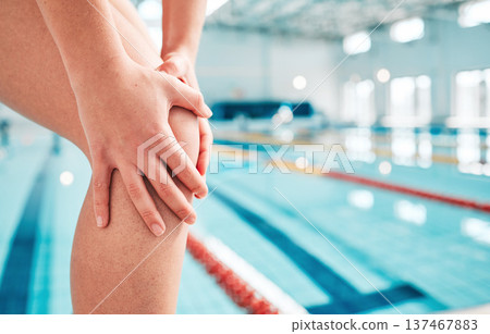 Person, hands and swimming in knee injury, ache or pain from sports accident or emergency by indoor pool. Closeup of sports athlete or swimmer with sore legs, arthritis or wound in fitness training 137467883