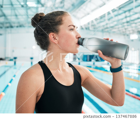 Swimmer, sports or woman drinking water to relax on break after exercise, workout or fitness training. Hydrate, thinking or girl athlete with liquid bottle for wellness or health by swimming pool Swimmer, sports or woman drinking water to relax on break after exercise, workout or fitness training. Hydrate, thinking or girl athlete with liquid bottle for wellness or health by swimming pool 137467886