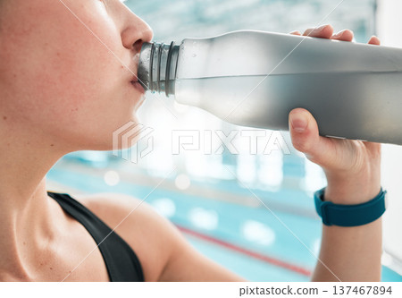 Swimmer, bottle or woman drinking water to relax on break after exercise, workout or fitness training. Hydrate, closeup or sports girl athlete with liquid for wellness or health by swimming pool Swimmer, bottle or woman drinking water to relax on break after exercise, workout or fitness training. Hydrate, closeup or sports girl athlete with liquid for wellness or health by swimming pool 137467894