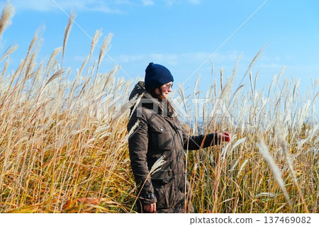 Russian woman 35 years old walking through miscanthus grassland in autumn Far East Russia enjoying nature freedom mindfulness and slow solo travel 137469082