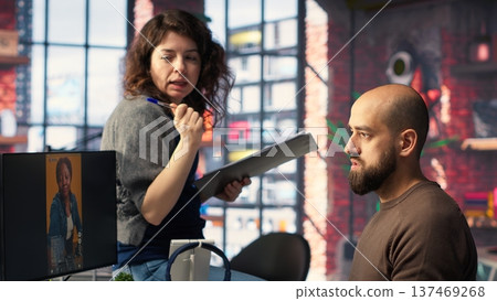 In a tech driven studio, team edits smartphone video footage on a dual monitors setup, applying professional tools for video creation. Targeting algorithm shifts and maximizing engagement. Camera B. In a tech driven studio, team edits smartphone video footage on a dual monitors setup, applying professional tools for video creation. Targeting algorithm shifts and maximizing engagement. Camera B. 137469268