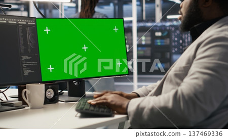 Data center admin using isolated screen PC to monitor neural network AI. Server room employee using mockup computer to oversee rigs powering machine learning processes, camera A Data center admin using isolated screen PC to monitor neural network AI. Server room employee using mockup computer to oversee rigs powering machine learning processes, camera A 137469336