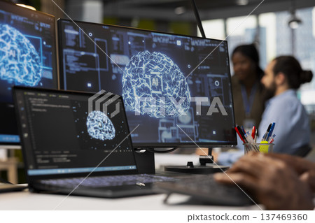 Close up of programmer in office integrating AI machine learning systems to streamline workflows. IT specialist uses neural networks artificial intelligence, technology overload concept Close up of programmer in office integrating AI machine learning systems to streamline workflows. IT specialist uses neural networks artificial intelligence, technology overload concept 137469360
