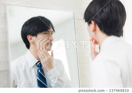 A young man looking at a mirror A young man looking at a mirror 137469810