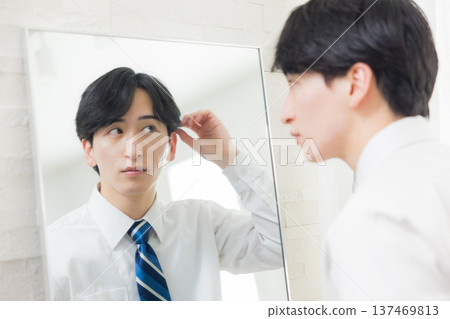 A young man looking at a mirror 137469813