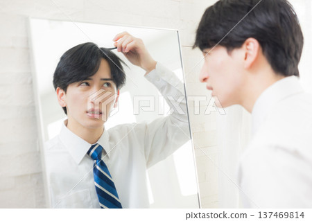 A young man looking at a mirror A young man looking at a mirror 137469814