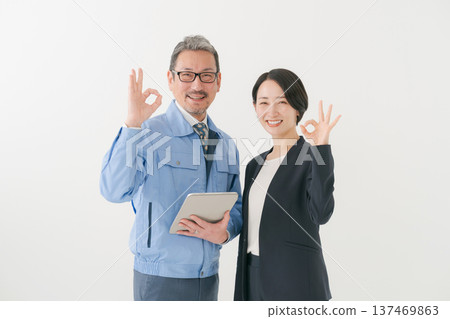 A man in work clothes and a woman in a suit making an OK pose 137469863