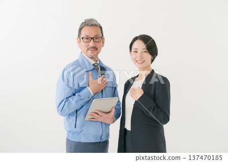 Smiling man in work clothes and woman in suit Smiling man in work clothes and woman in suit 137470185