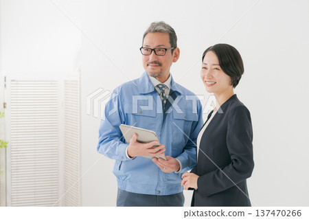 一名身穿工作服的男子和一名身穿西裝的女子正在開會 137470266