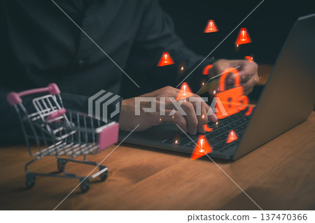 Cybersecurity risk in online shopping illustrated with warning icons and a digital lock as a person enters card details on a laptop, representing fraud alerts, payment security, and data protection. Cybersecurity risk in online shopping illustrated with warning icons and a digital lock as a person enters card details on a laptop, representing fraud alerts, payment security, and data protection. 137470366