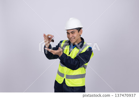 Mechanic in safety vest holding metal wrenches 137470937