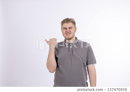 Man in gray t-shirt pointing thumb to the side Man in gray t-shirt pointing thumb to the side 137470938
