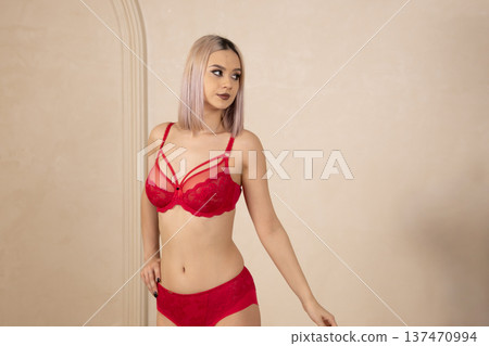Woman in red lingerie set posing in studio 137470994