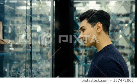 Man choosing glasses near a glass display 137471005