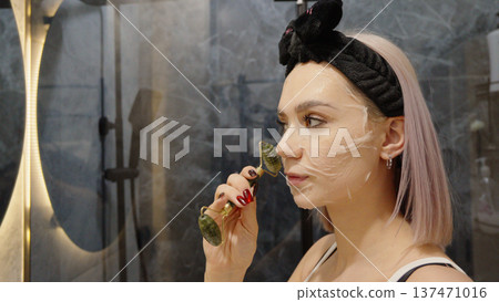 Girl applying face mask with a brush at home 137471016