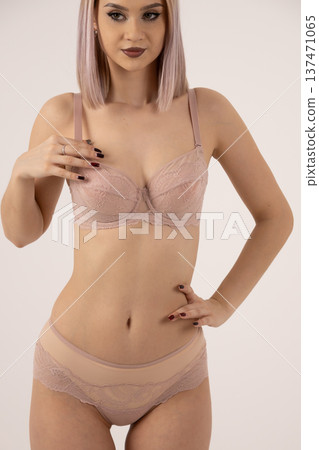 Young woman in beige lingerie and silk robe 137471065