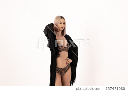 Woman in black coat and lingerie posing on white Woman in black coat and lingerie posing on white 137471080
