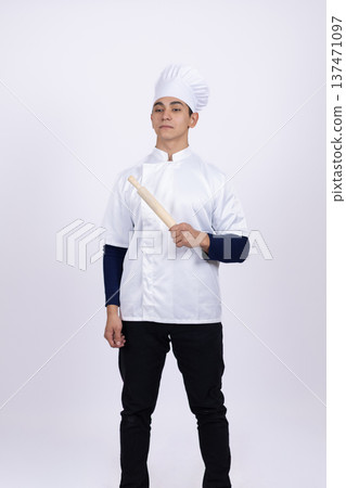 Portrait of a young chef in white coat and hat 137471097