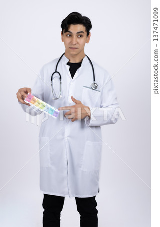 Smiling doctor holding various medical pills and vitamins 137471099