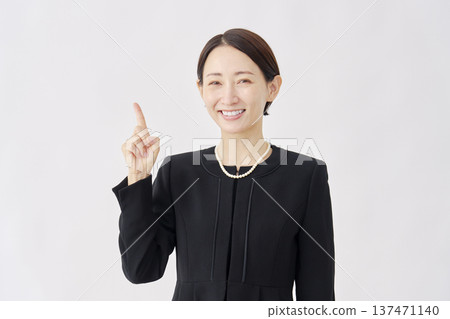 身著喪服的女子指向左側，白色背景 137471140