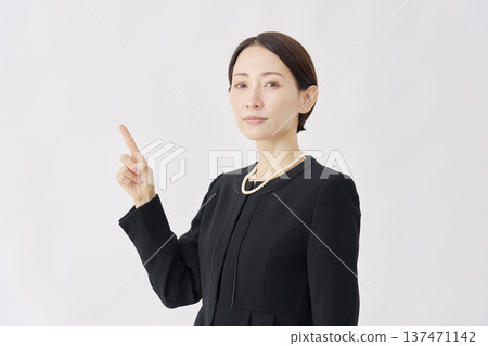 Woman in mourning clothes pointing to the left, white background 137471142