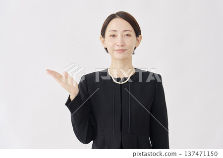 身著喪服的女子指向左側，白色背景 137471150