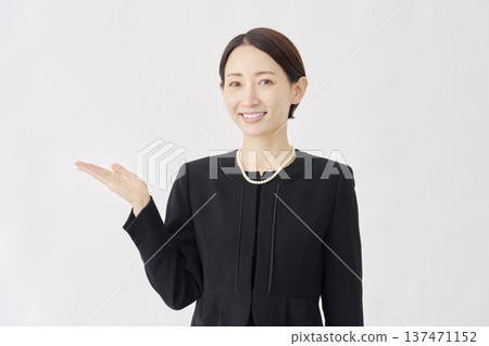 身著喪服的女子指向左側，白色背景 137471152
