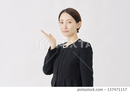 身著喪服的女子指向左側，白色背景 137471157