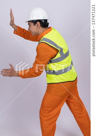 Builder pushing an invisible wall in a studio Builder pushing an invisible wall in a studio 137471221