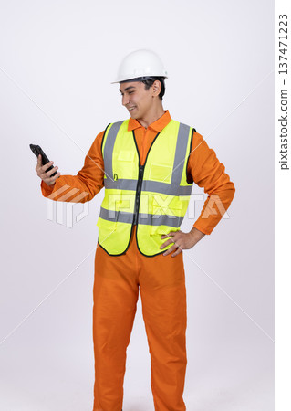 Worker in safety vest using a walkie talkie Worker in safety vest using a walkie talkie 137471223