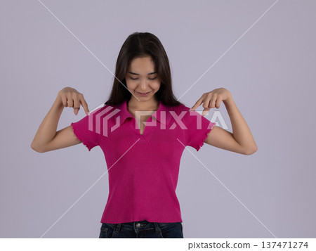Woman in pink shirt pointing fingers down at floor 137471274