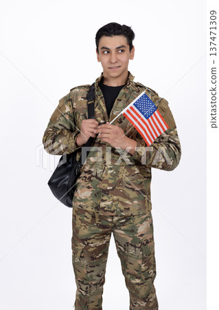 Military man in camouflage holding an American flag 137471309
