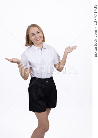 Young woman in white shirt shrugging her shoulders in studio 137471439