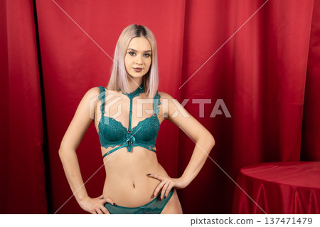 Woman in teal lingerie posing against red curtains Woman in teal lingerie posing against red curtains 137471479
