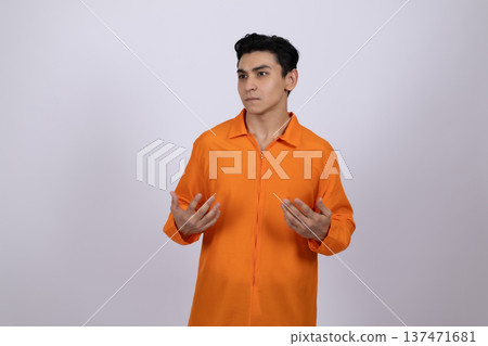 Man in orange overalls gesturing with open hands in studio Man in orange overalls gesturing with open hands in studio 137471681