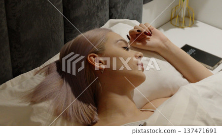 Young blonde woman sleeping in bed during the night Young blonde woman sleeping in bed during the night 137471691