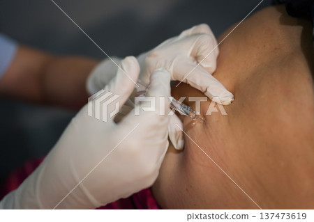 close up doctor is injecting enoxaparin injection to belly with syringe close up doctor is injecting enoxaparin injection to belly with syringe 137473619