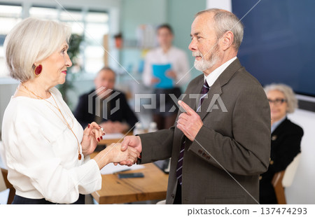 Man and woman shake hands in gratitude after signing a contract at business meeting 137474293