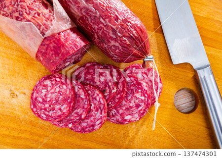 Sliced Iberian dry cured pork sausage salchichon on wooden background Sliced Iberian dry cured pork sausage salchichon on wooden background 137474301