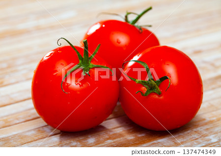 Three ripe red tomatoes over wooden background 137474349